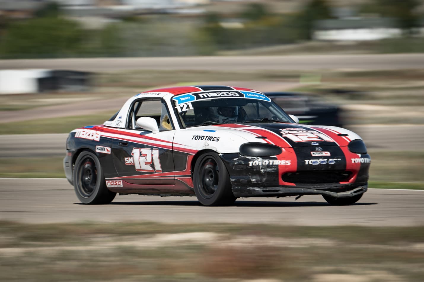 Mazda #121 race car with NASA and Toyo Tires markings on a racetrack